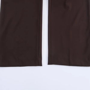 Detailed macro view of the straight leg hem and clean stitching on brown trousers