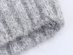 Macro detail of soft light grey knit fabric with fluffy mohair-like texture and fibers