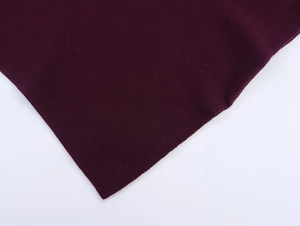 Close-up of deep purple ribbed knit fabric texture on an irregular batwing sweater