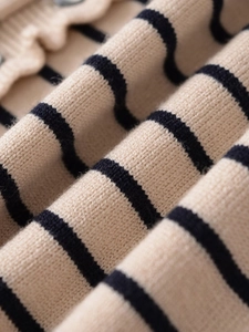 Vue macro du tissu tricoté rayé montrant la texture douce et les motifs beige et bleu