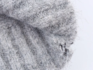 Macro shot of grey knit sweater showing soft fluffy texture and detailed wool fibers