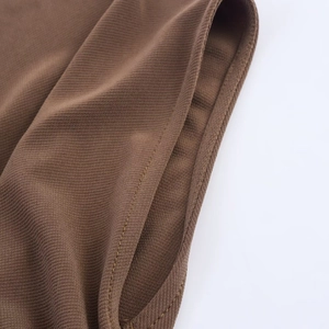Close-up of brown ribbed knit fabric texture showing fine stitching and premium edge finish