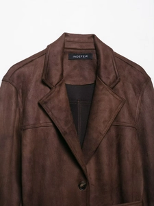 Detail of dark brown faux suede jacket collar with brand tag and premium stitching