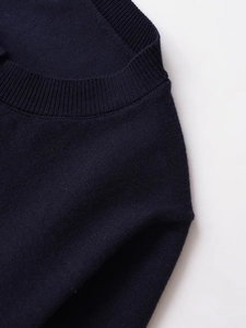Détail du col rond côtelé bleu marine et texture de maille fine sur le pull femme