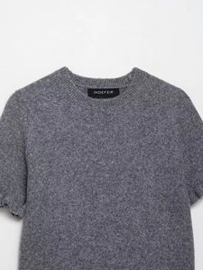 Dettaglio di un maglione grigio a maniche corte in maglia con girocollo e bordi a coste