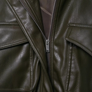 Veste en similicuir vert foncé minimaliste avec fermeture éclair argentée et poches à rabat