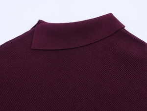 Macro shot of burgundy ribbed knit sweater showing refined polo collar and seam details