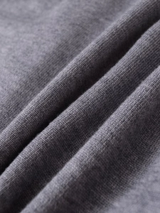 Close-up detail of soft grey fine knit fabric showing smooth texture and high quality
