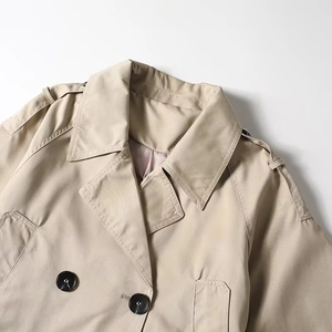Classic double-breasted short trench coat with wide lapels and shoulder epaulettes in beige