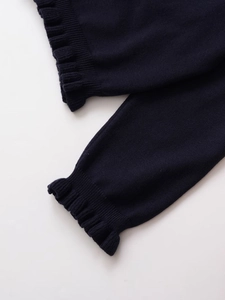 Vue détaillée du cardigan en tricot bleu marine avec poignets à volants et texture