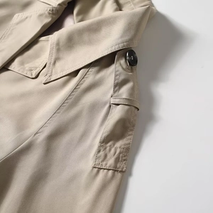 Close-up of lapel collar and shoulder epaulettes on a khaki cropped trench coat jacket