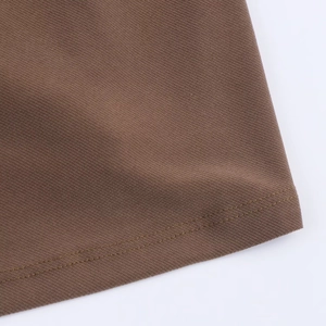 Close-up of the fine twill texture and neat double-needle hem on a brown dress