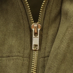 Close-up of golden metal zipper on vintage olive faux suede bomber jacket for women