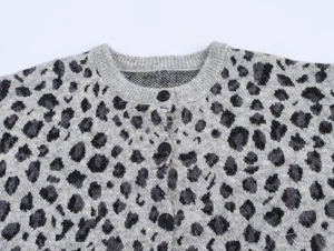 Close-up of leopard jacquard knit cardigan featuring round neck and black textured buttons