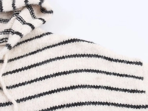 Close-up of the black and white striped knit texture and drawstring hood detail