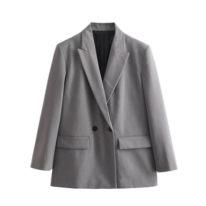 Detail view of double-breasted grey blazer featuring black buttons and flap pockets