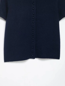 Detail of navy blue short sleeve knit cardigan showing fabric texture and cloth buttons