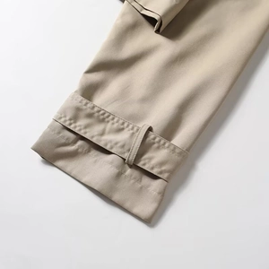 Detail of khaki trench coat sleeve with adjustable strap and refined stitching