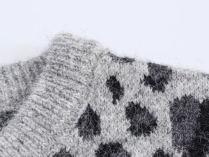 Detailed close-up of fluffy leopard jacquard knit fabric on gray cardigan sweater
