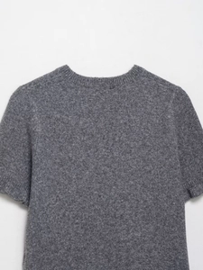 Dettaglio del maglione grigio in maglia che mostra la texture morbida della lana