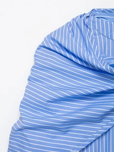 Detail of blue and white pinstripe fabric showing smooth texture and high-quality weave