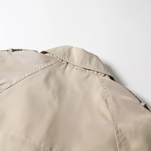 Detail of classic khaki trench coat back collar with shoulder straps and twill texture