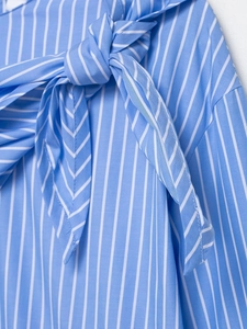 Detailed view of blue and white striped shirt featuring a decorative bow tie accent