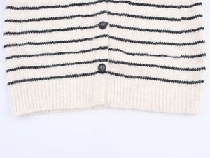 Detailed close-up of soft knit cardigan texture with black and white horizontal stripes