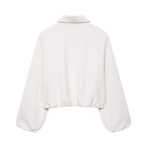Vue détaillée de la veste bouffante blanche avec manches larges et ourlet élastique