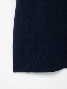 Close-up of dark blue knit sweater hem featuring high-quality ribbed cuff texture