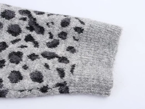 Close-up of leopard jacquard knit texture and elastic ribbed cuffs on the gray sweater
