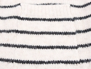Detail shot of striped knit sweater fabric showing soft fuzzy mohair texture and a flat pocket