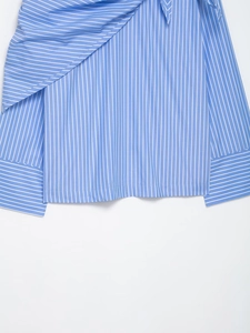 Detail of blue and white striped shirt featuring wrap-around tie waist design