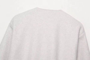 Gros plan sur la texture molletonnée douce et la couture d'épaule de ce blouson aviateur
