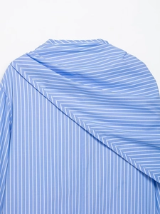Detailed close-up of blue and white striped shirt featuring draped layered back design