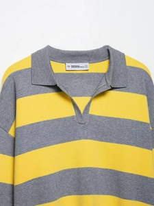 Detail view of a striped knit polo sweater with V-neckline and yellow and grey pattern