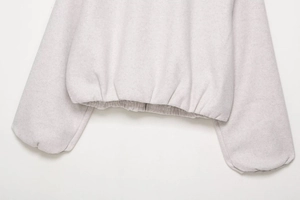 Détail de la veste bomber en polaire gris clair avec ourlet élastique et poignets côtelés