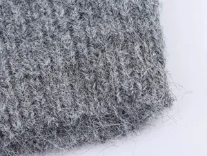 Vista macro dettagliata del tessuto a maglia grigio con morbida trama a pelo lungo e onde