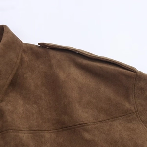 Detailed close-up of dark brown faux suede fabric on the shoulder of a pilot jacket