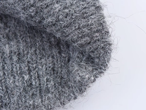 Vista macro di tessuto a maglia grigio chiaro con fibre morbide e trama fitta dettagliata