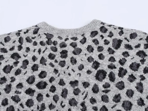 Close-up of leopard pattern knit texture on grey crewneck fluffy cardigan sweater