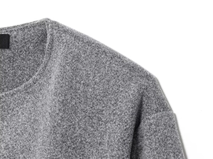 Détail de la texture en maille grise douce et de l'encolure ronde classique du blouson aviateur