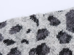 Macro view of leopard jacquard knit fabric showing warm mohair texture and fiber detail