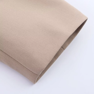 Detailed macro view of the woven texture and seamless hem of khaki oversized blazer