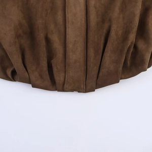 Close-up of the dark brown faux suede texture and hem detail on a bomber jacket