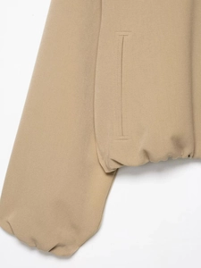 Détail de la poche de la veste bouffante kaki et ourlet élastique en tissu sergé