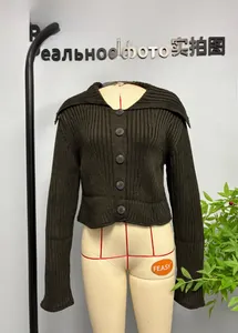Détail d'un cardigan en maille côtelée vert olive avec grand col et boutons frontaux