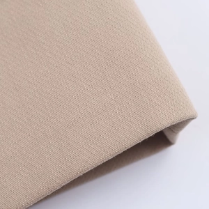 Macro detail of high-density khaki canvas fabric showing woven texture and edge stitching