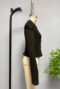 Détail d'un cardigan en grosse maille côtelée avec grand col et fermeture à boutons