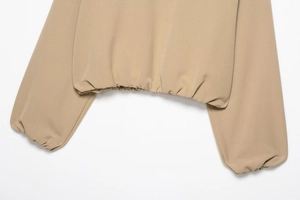 Vue détaillée de l'ourlet et des poignets élastiques d'une veste zippée kaki